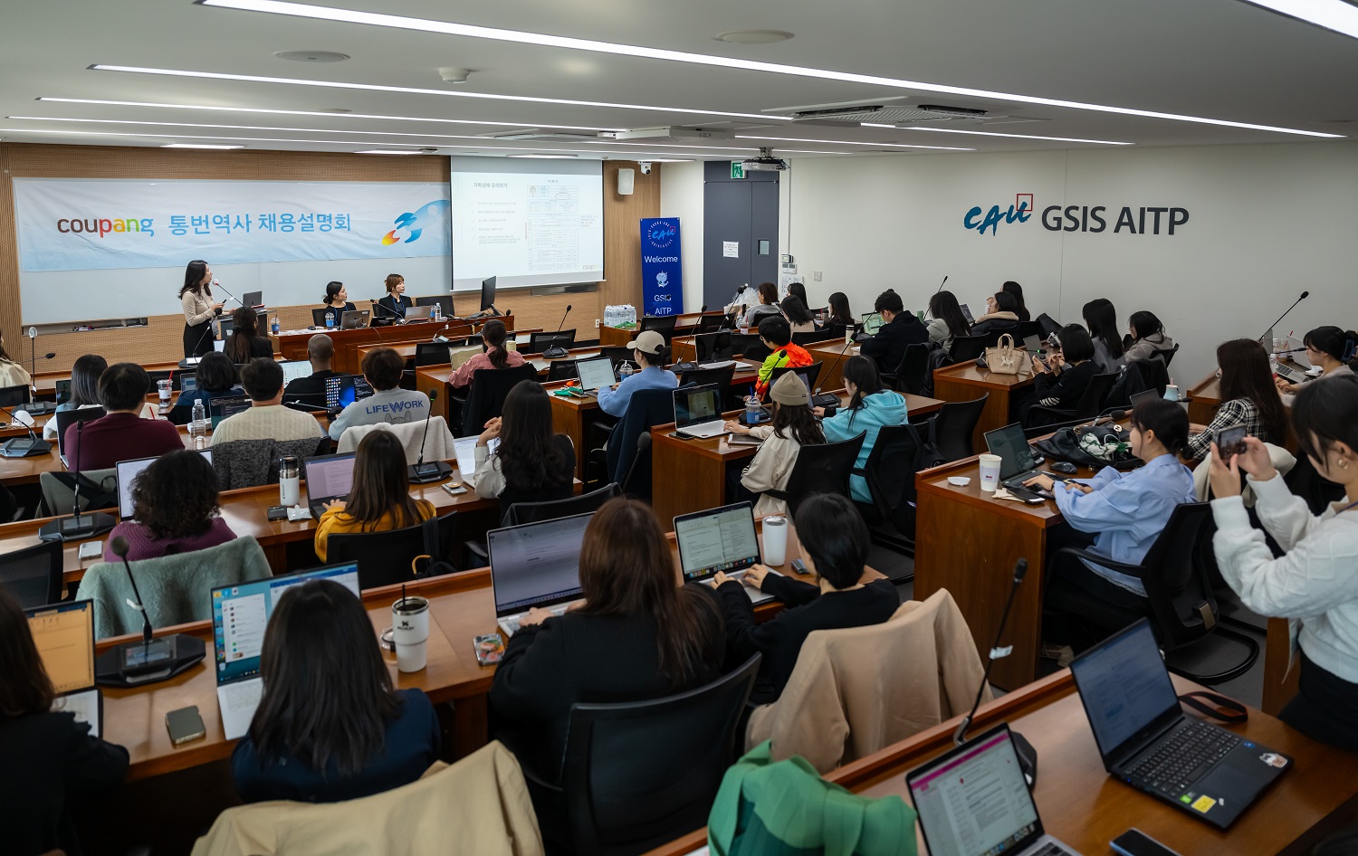 컴퓨터가 있는 방에 있는 한 무리의 사람들