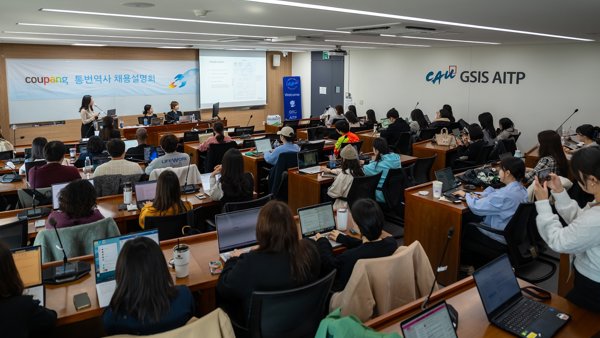 컴퓨터가 있는 방에 있는 한 무리의 사람들