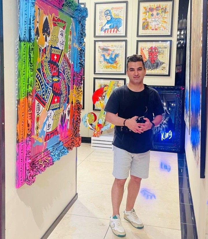 a person standing in a hallway with art on the wall