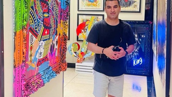 a person standing in a hallway with art on the wall