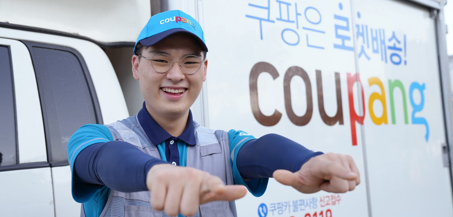 파란 모자를 쓰고 안경을 쓴 사람이 손가락으로 가리키고 있다