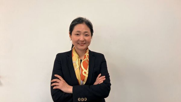 a person in a suit with her arms crossed
