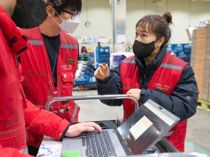 a person and person wearing face masks and red vests