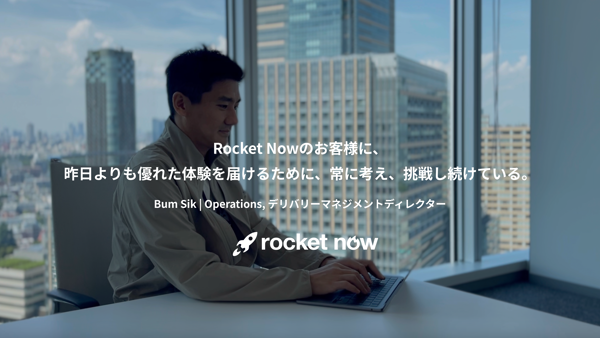 机に座ってノートパソコンを使う人