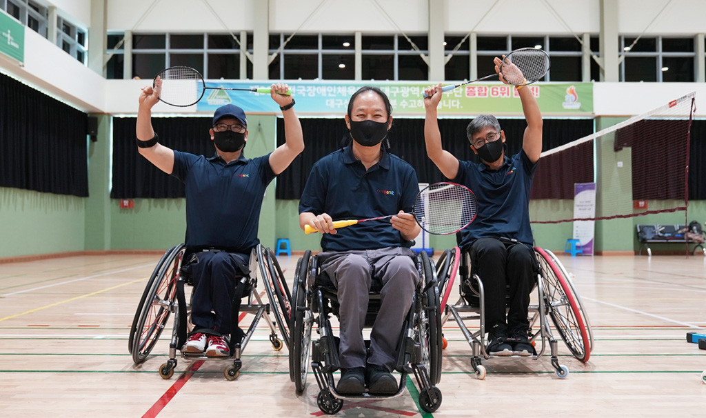 휠체어를 탄 사람들이 테니스 라켓을 들고 있는 모습