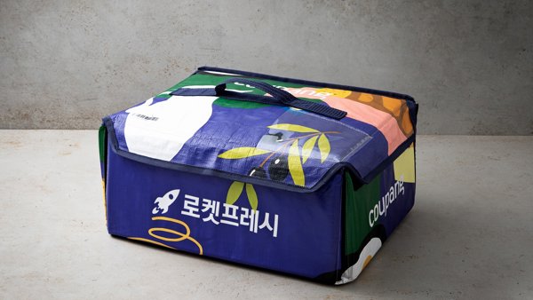 흰색 텍스트와 파란색 손잡이가 있는 파란색과 녹색 가방