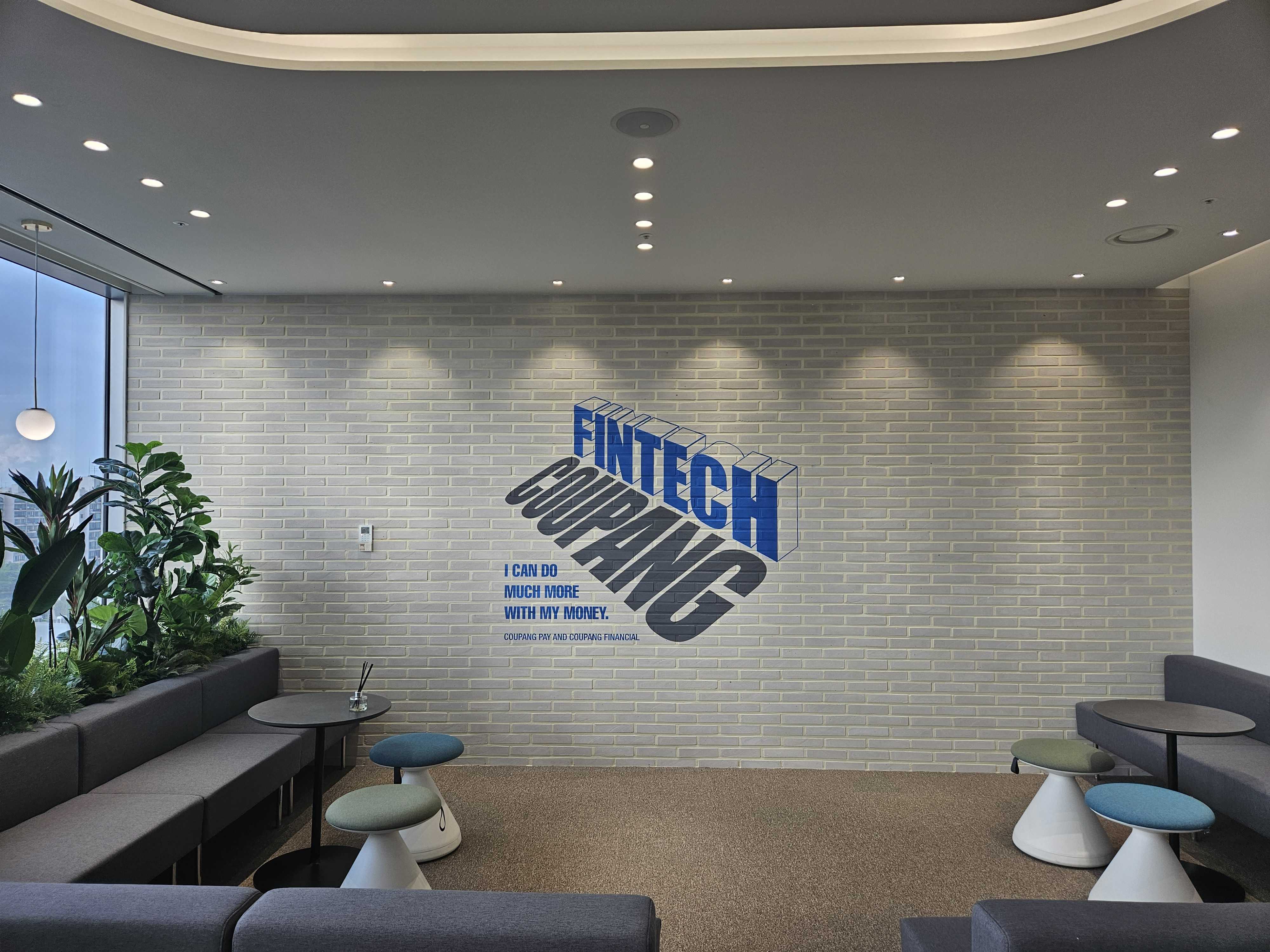 a room with a brick wall and a couch and a plant