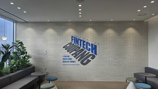 a room with a brick wall and a couch and a plant