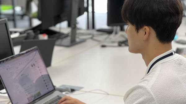 a person sitting at a desk using a laptop