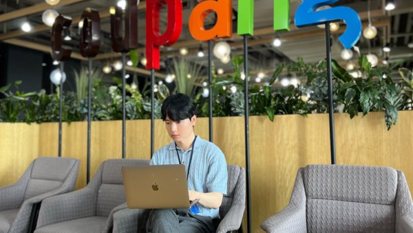 a person sitting in a chair with a laptop