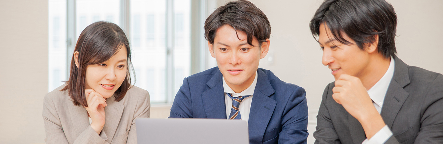 スーツとネクタイを着てノートパソコンを眺めている人