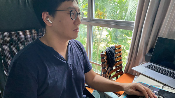 노트북과 창문이 있는 책상에 앉아 있는 사람