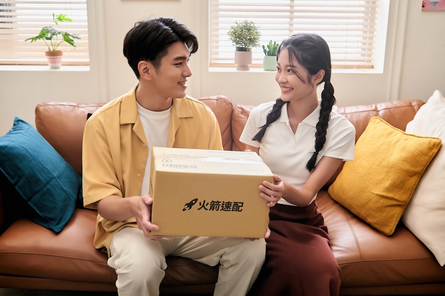 一個人和一個人坐在沙發上，手裡拿著一個盒子