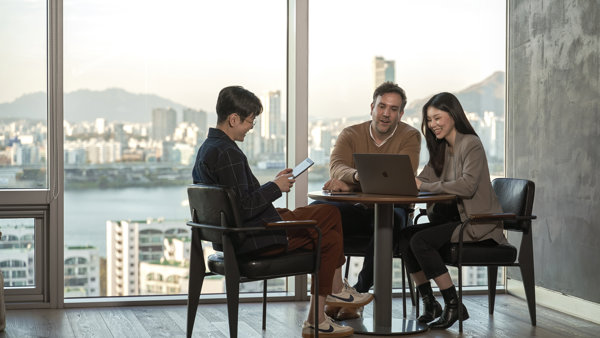 a group of people sitting at a table with a laptop
