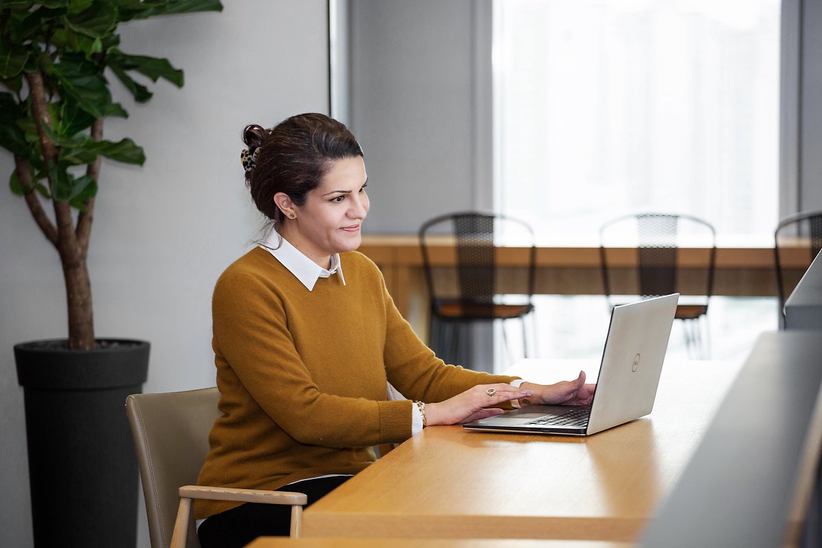 a person sitting at a table using a laptop