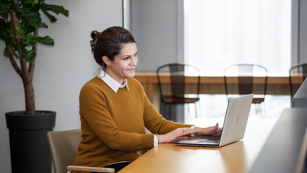 a person sitting at a table using a laptop