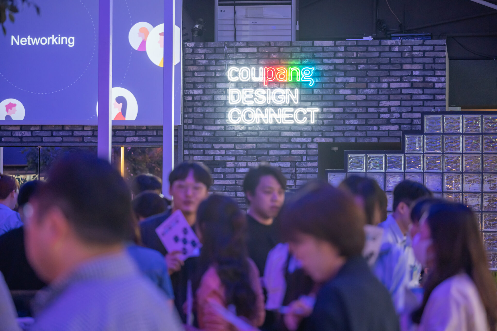 a group of people standing in front of a brick wall