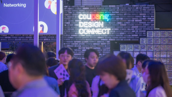 a group of people standing in front of a brick wall