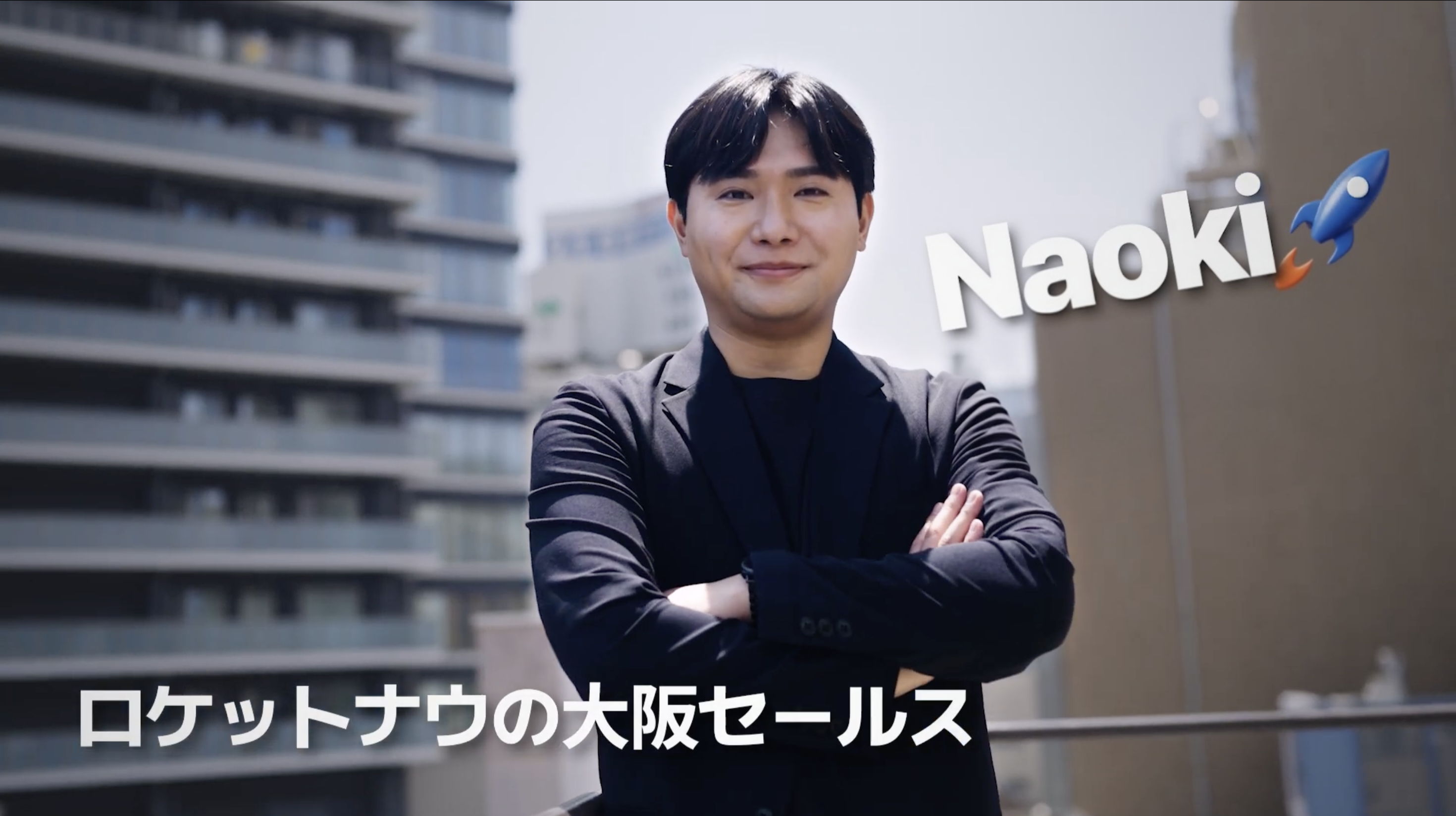 腕を組んだ黒いスーツの人物