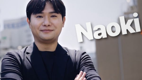 腕を組んだ黒いスーツの人物
