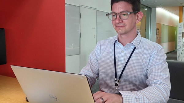 a person sitting at a desk with a laptop