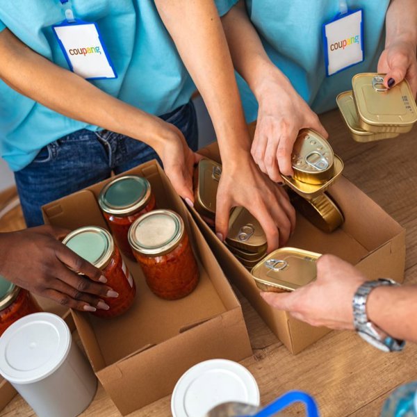 a group of people putting canned food into boxes