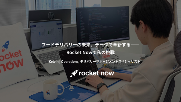机に座ってノートパソコンを操作している人
