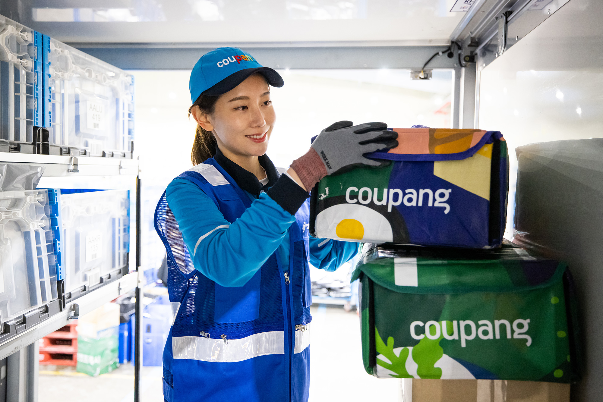 a person wearing a blue uniform and gloves holding a box