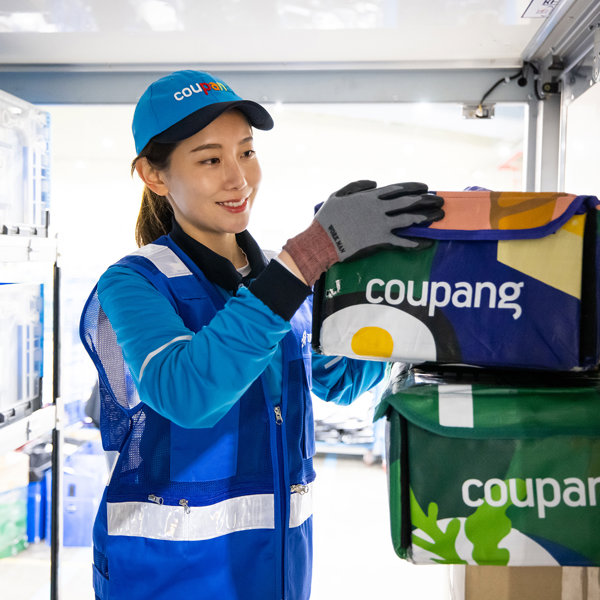 a person wearing a blue uniform and gloves holding a box