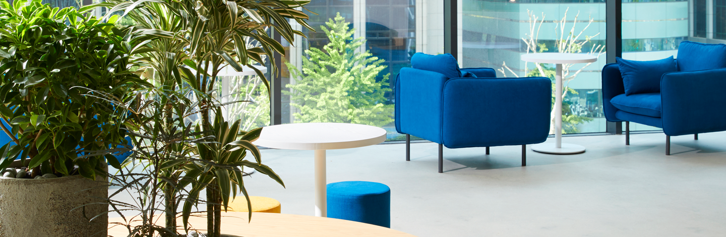 a white table and blue chairs in a room with a window