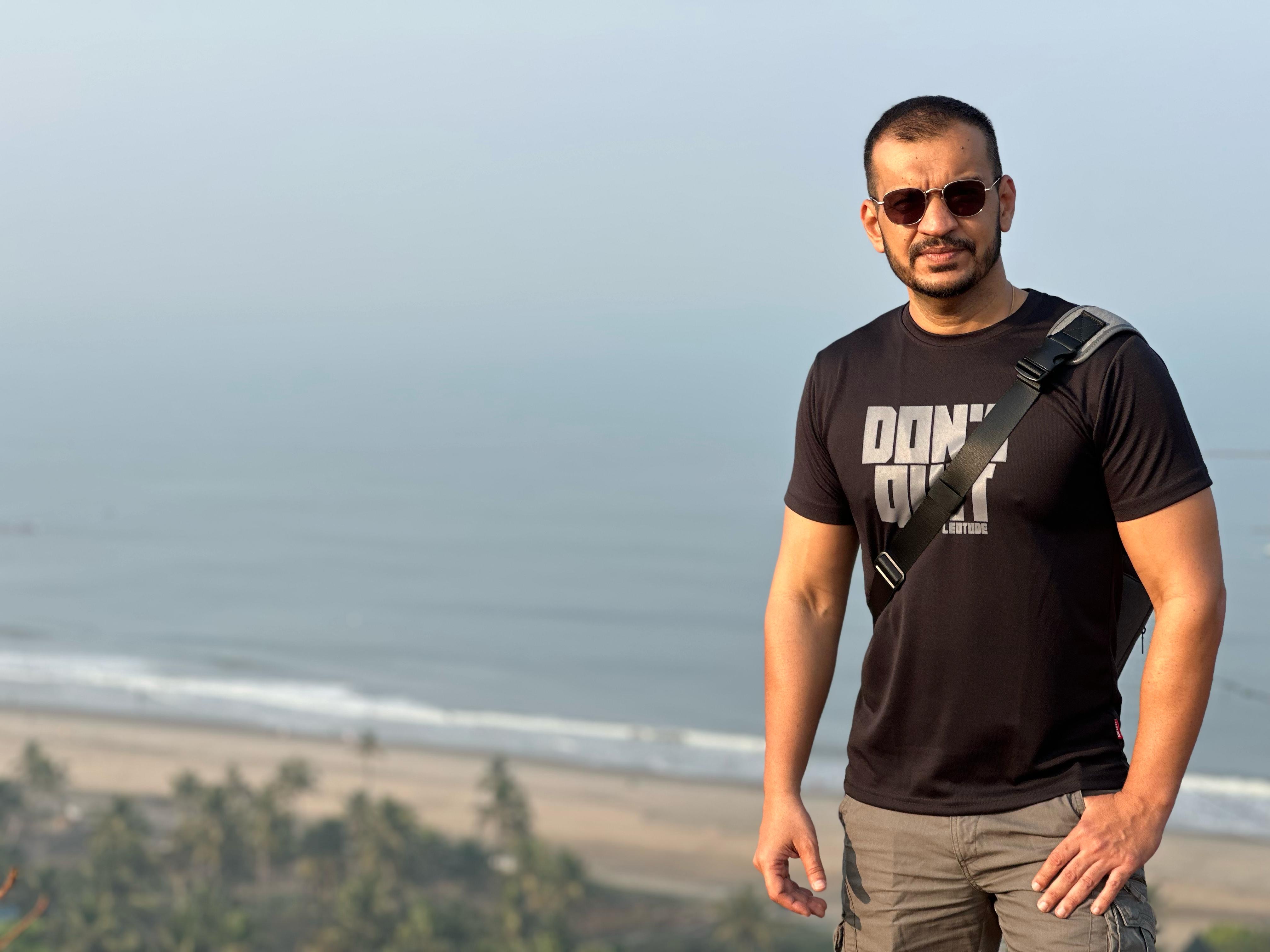 a person standing on a hill with a beach and trees