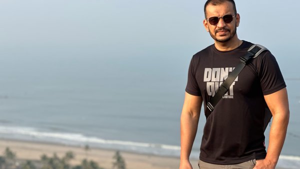 a person standing on a hill with a beach and trees