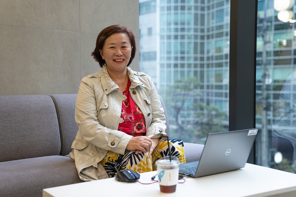 노트북을 들고 소파에 앉아 있는 사람