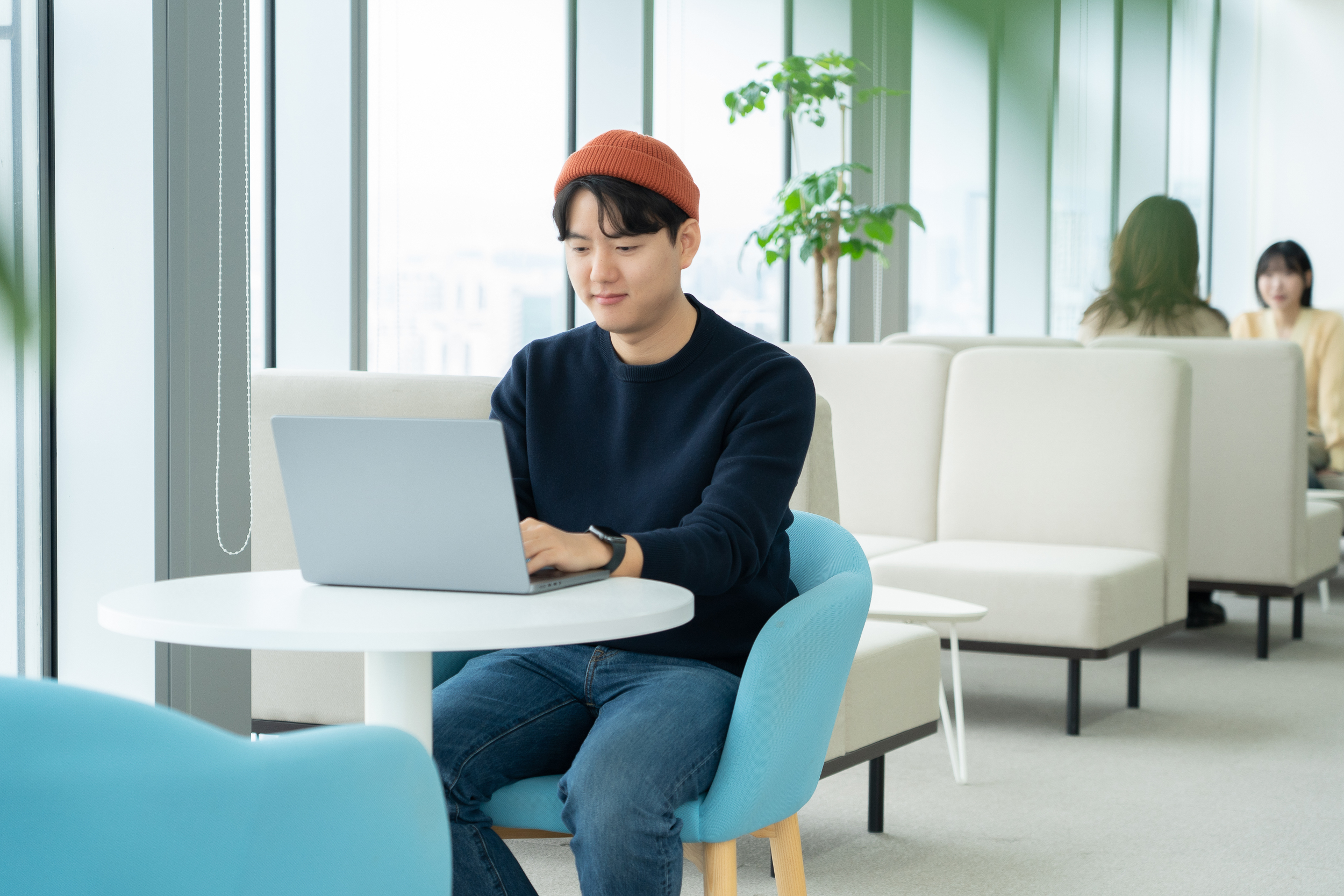 a person sitting at a table using a laptop