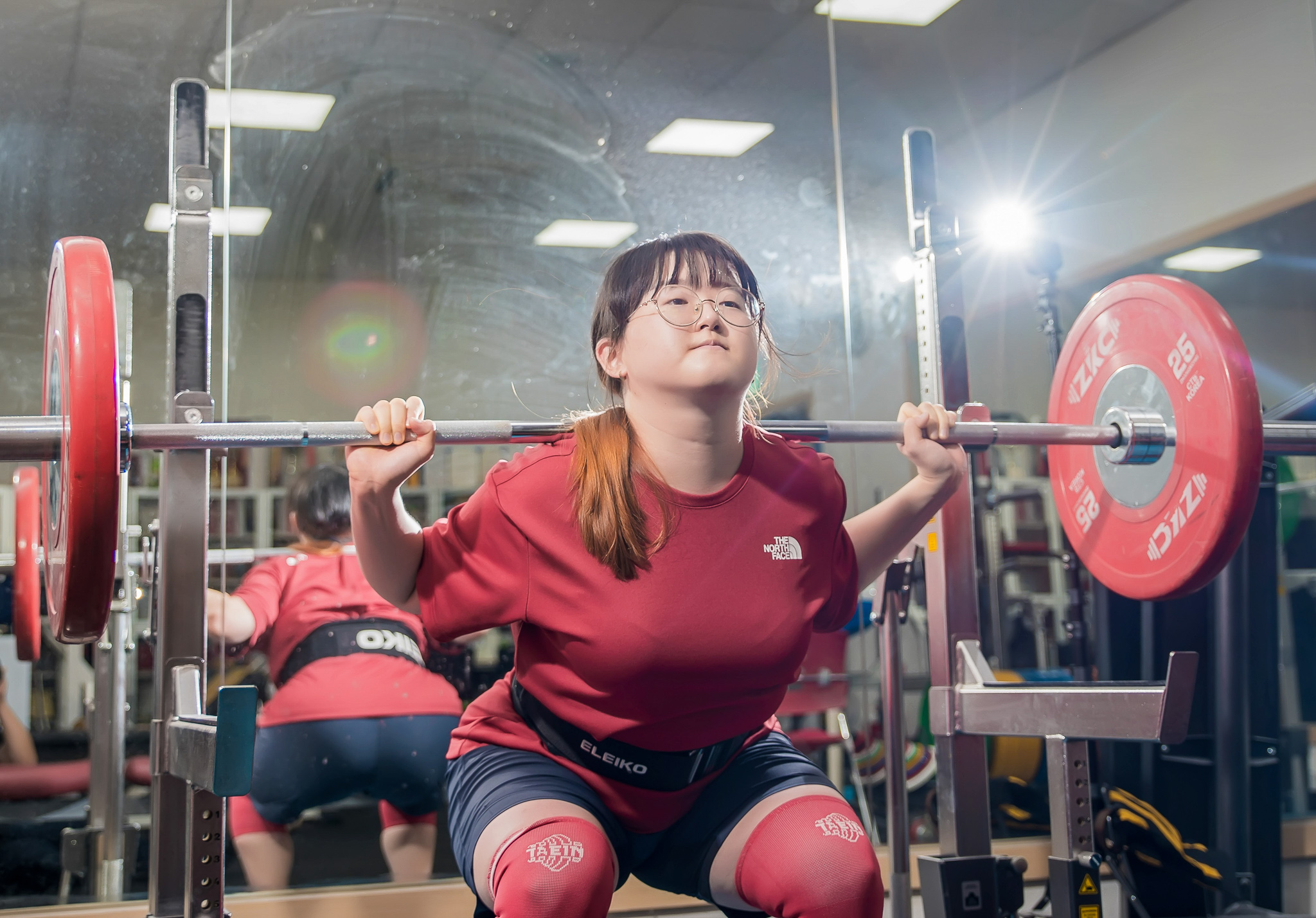 체육관에서 역기를 드는 사람