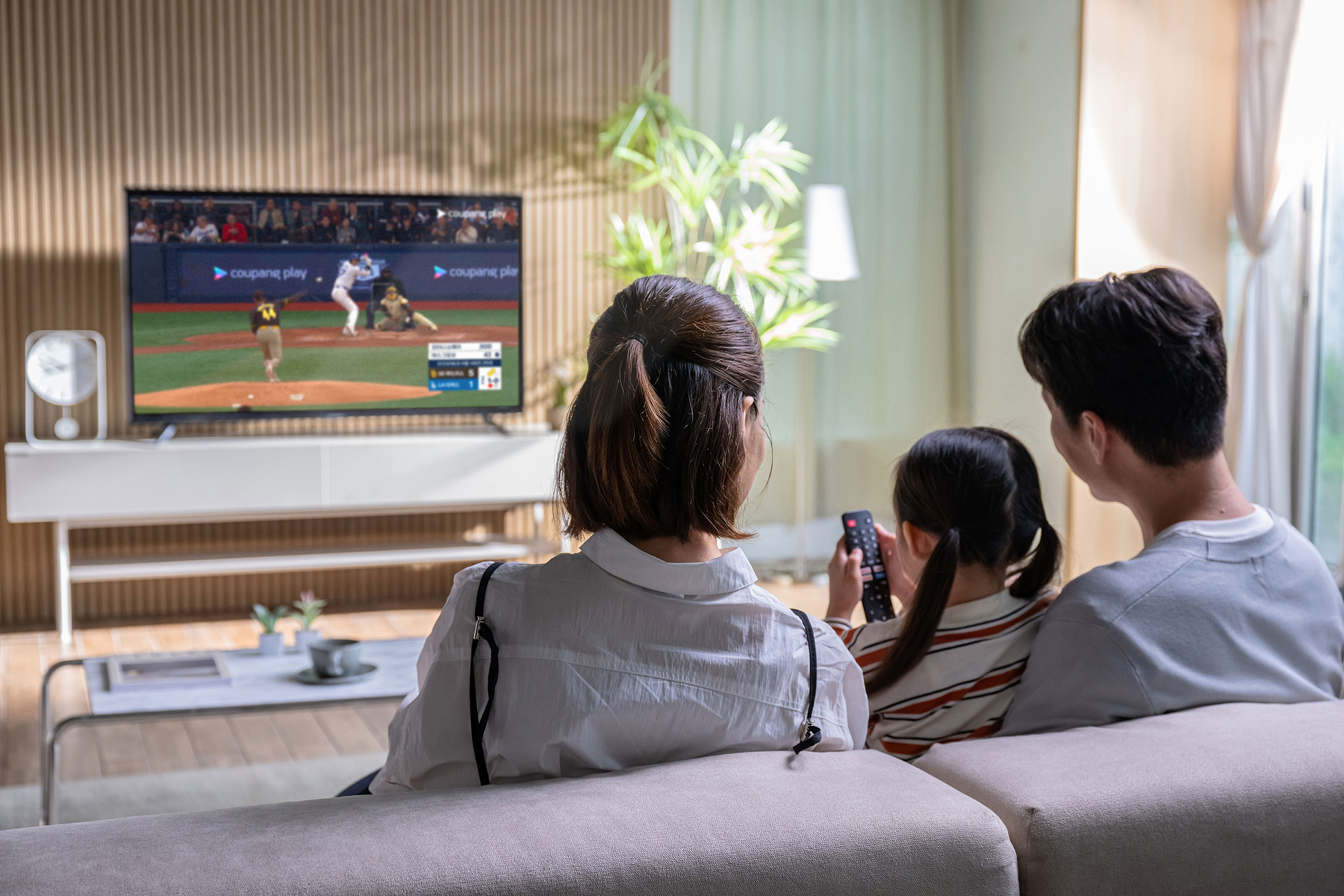 a group of people sitting on a couch watching a television