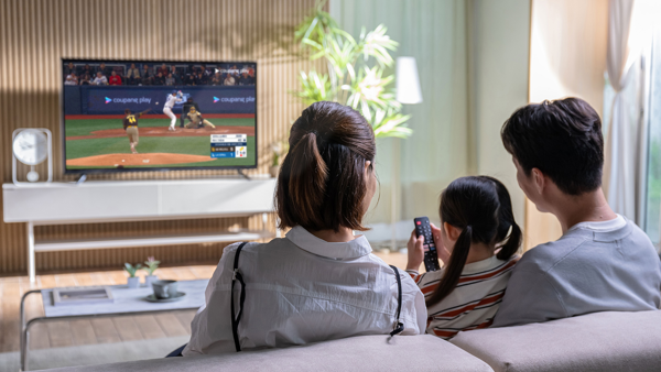 a group of people sitting on a couch watching a television