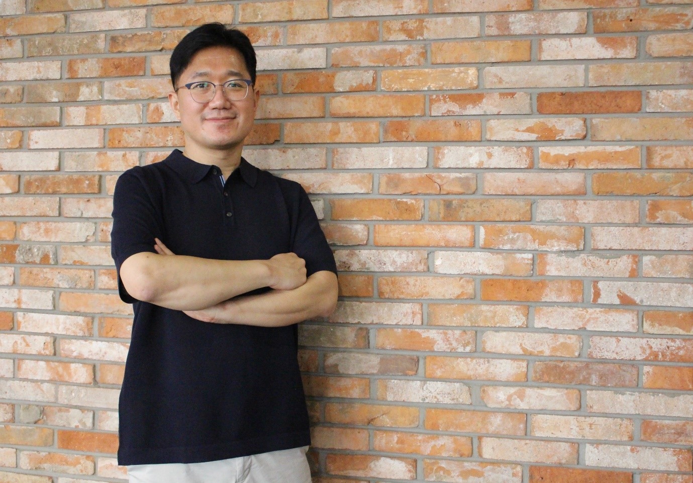 a person standing in front of a brick wall