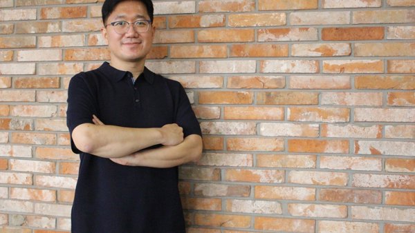 a person standing in front of a brick wall