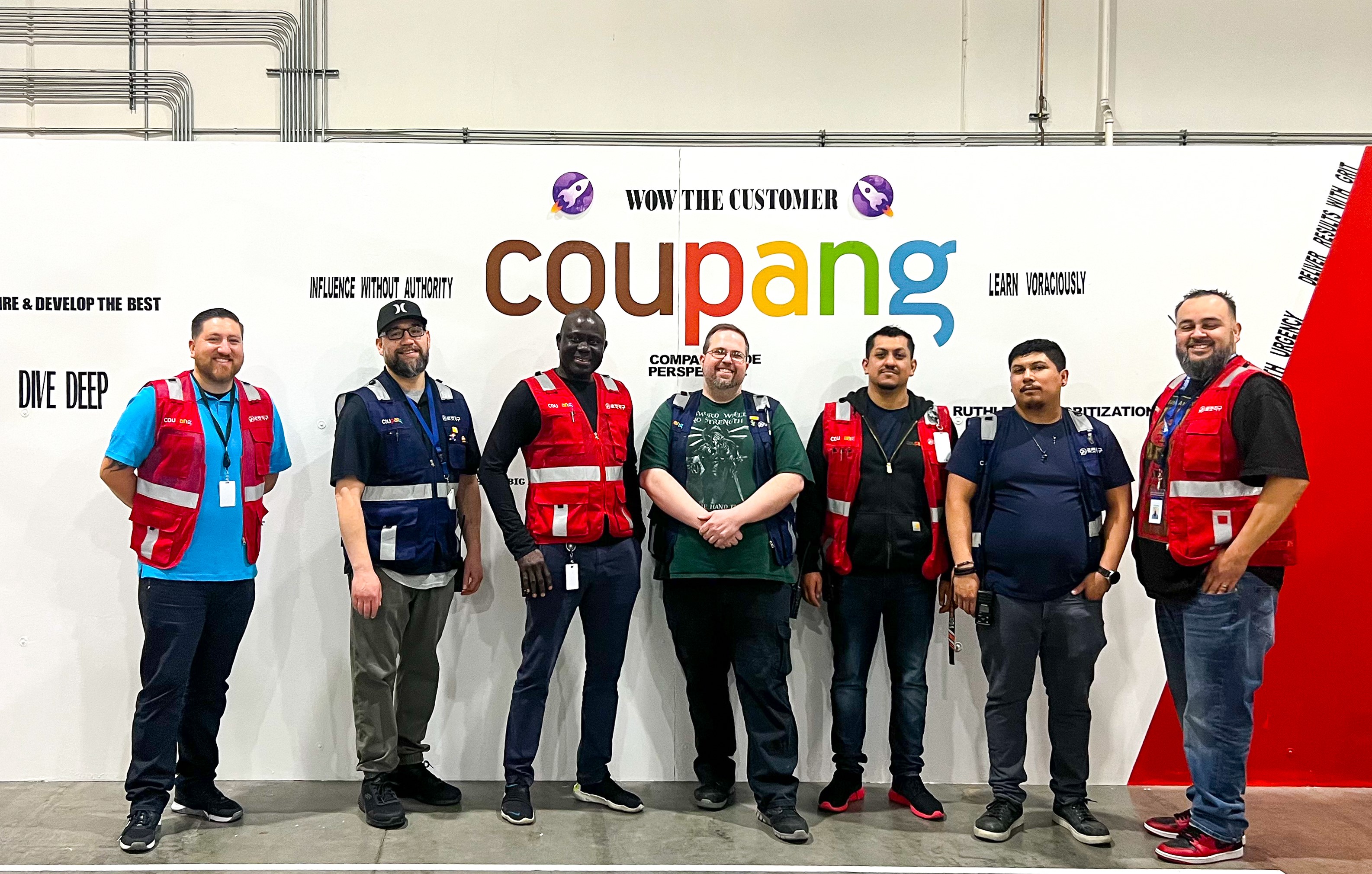 a group of men standing in front of a sign