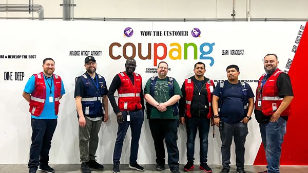 a group of men standing in front of a sign
