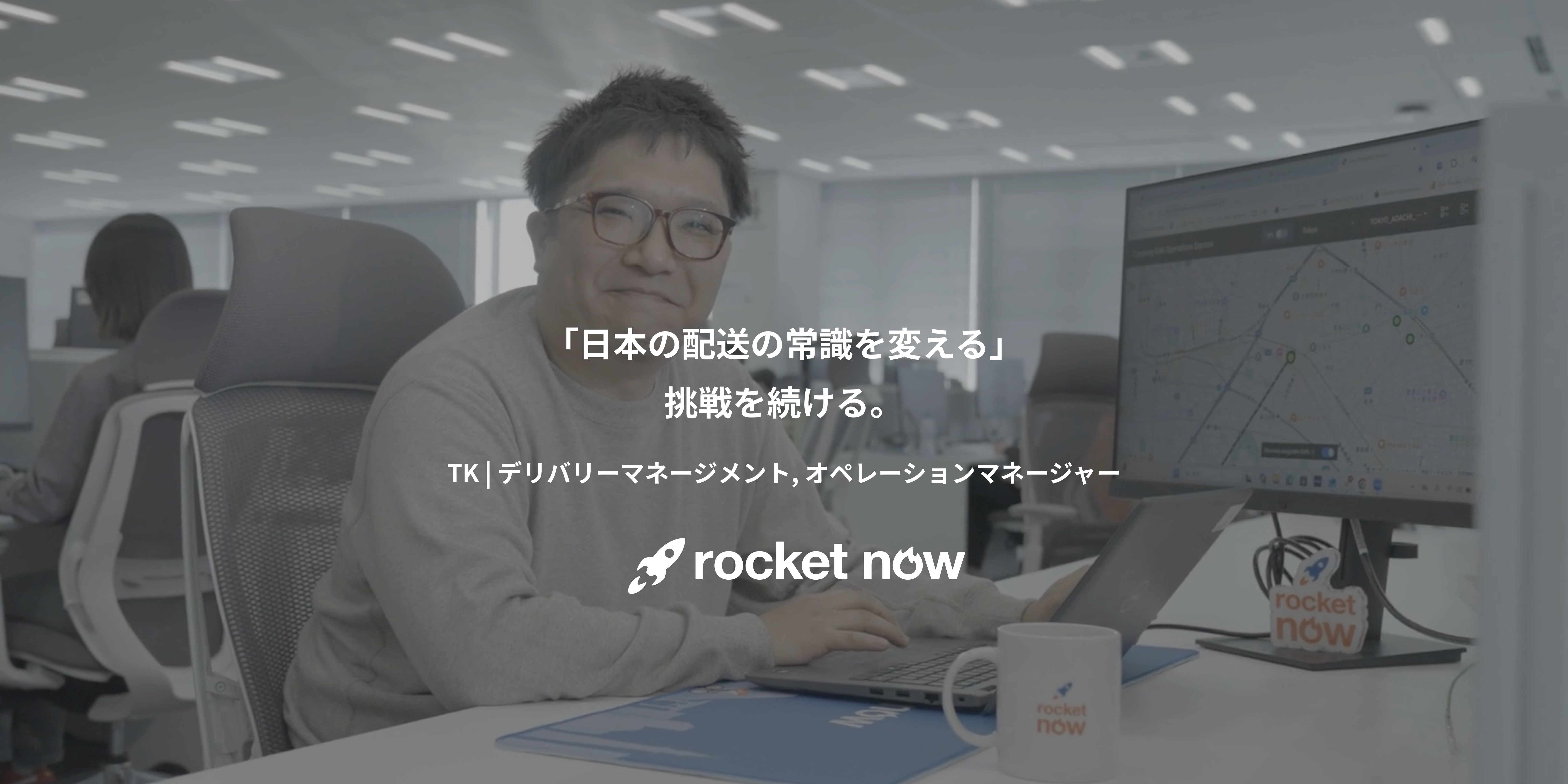 机に座ってノートパソコンを操作している人