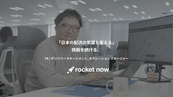 机に座ってノートパソコンを操作している人