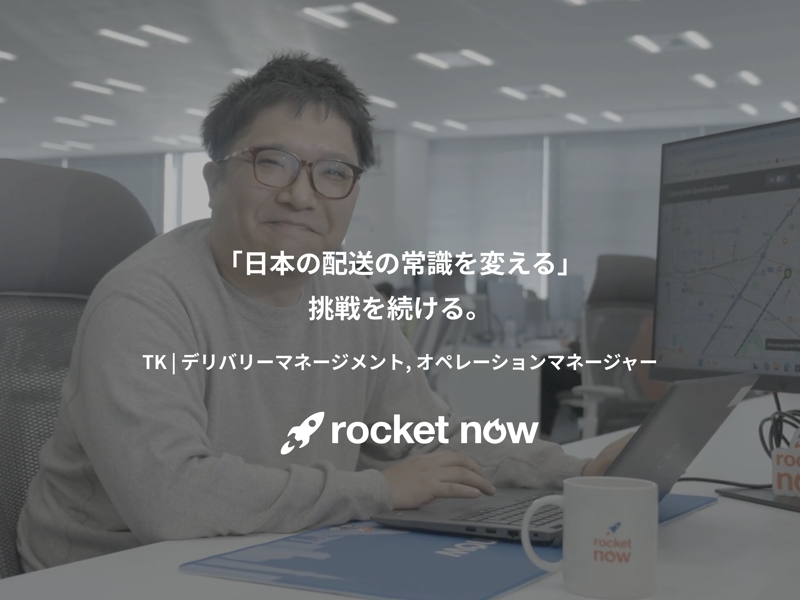 机に座ってノートパソコンを操作している人