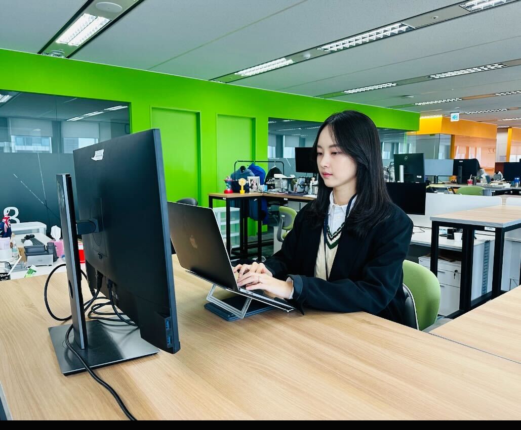 a person sitting at a desk with a laptop