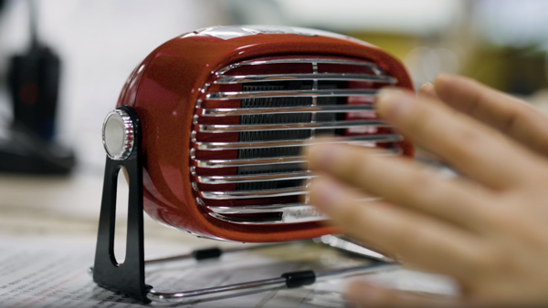 a hand touching a small red object