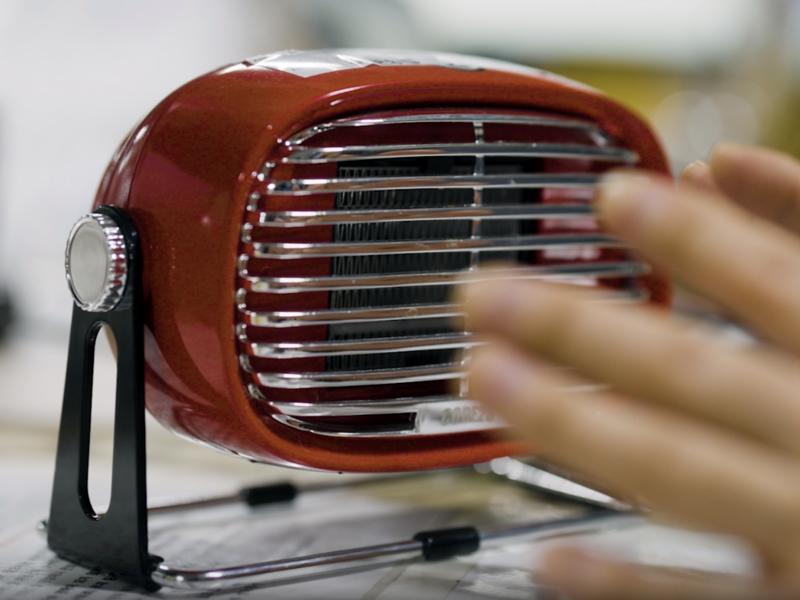 a hand touching a small red object