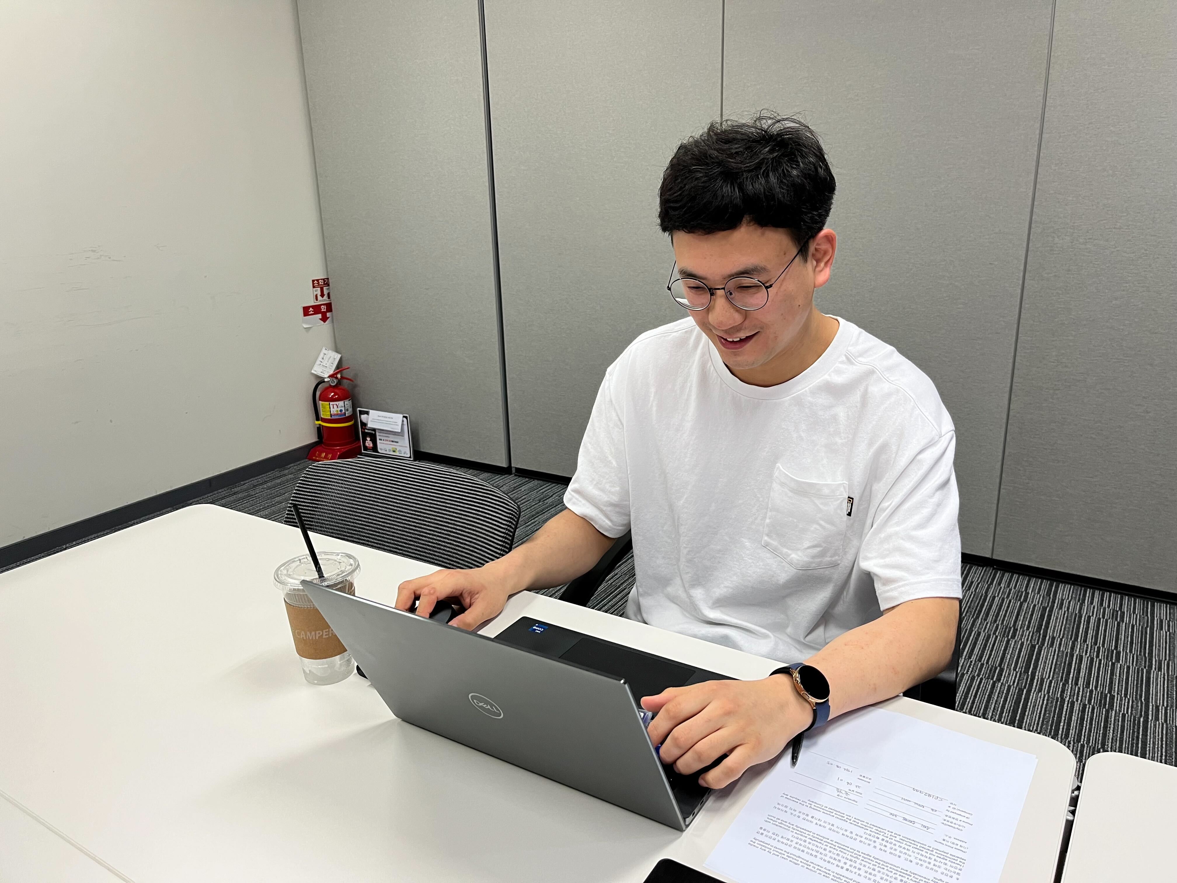 a person sitting at a desk using a laptop