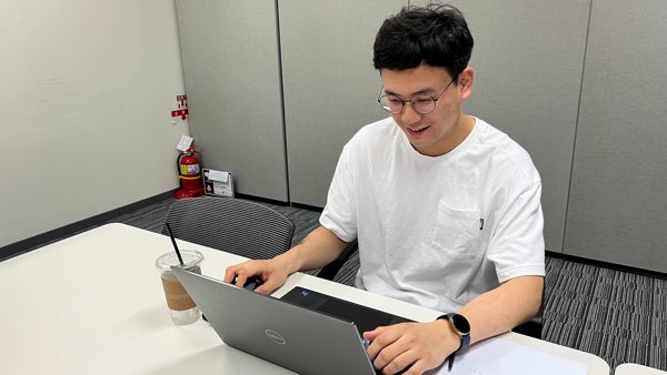 a person sitting at a desk using a laptop