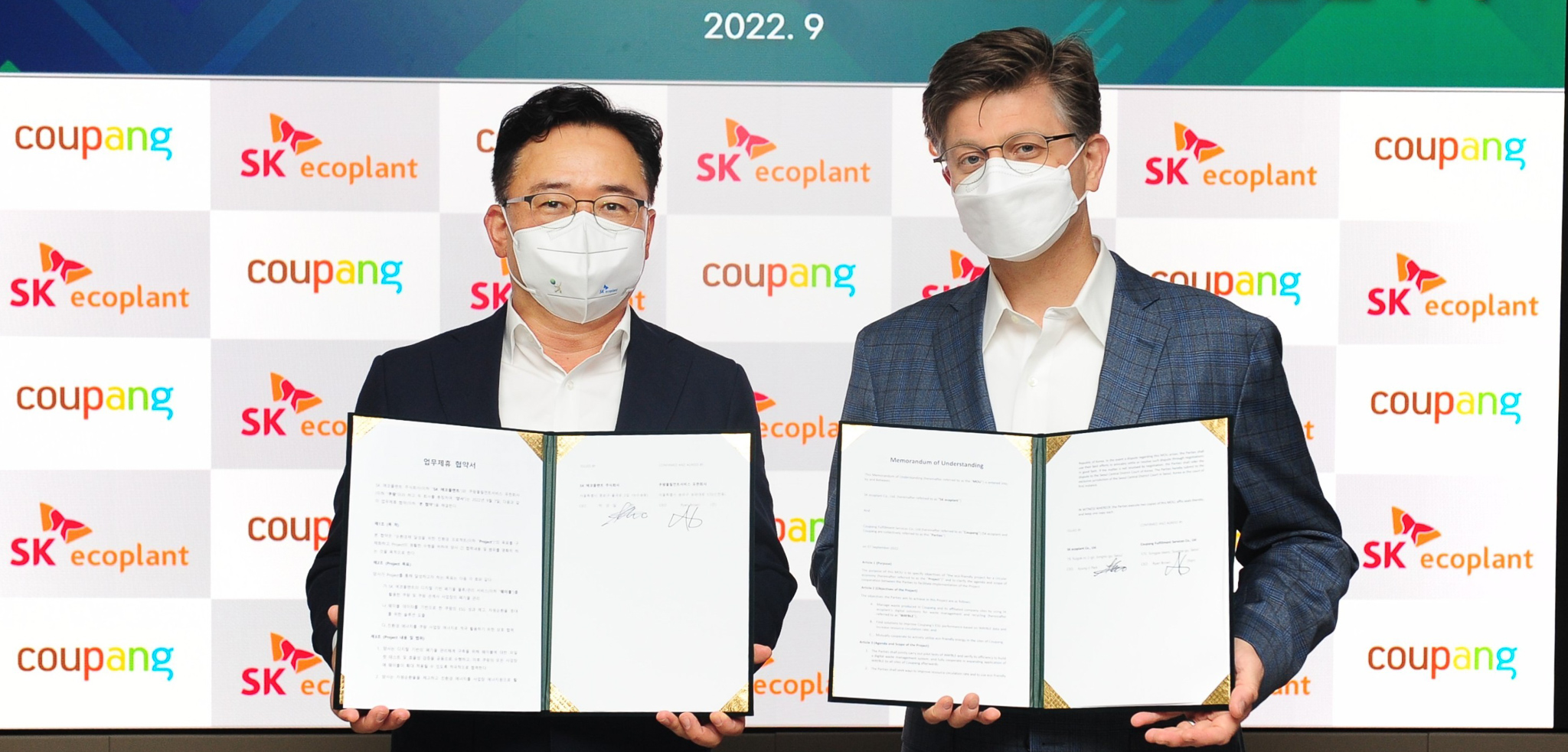 안면 마스크를 쓴 두 남자가 종이를 들고